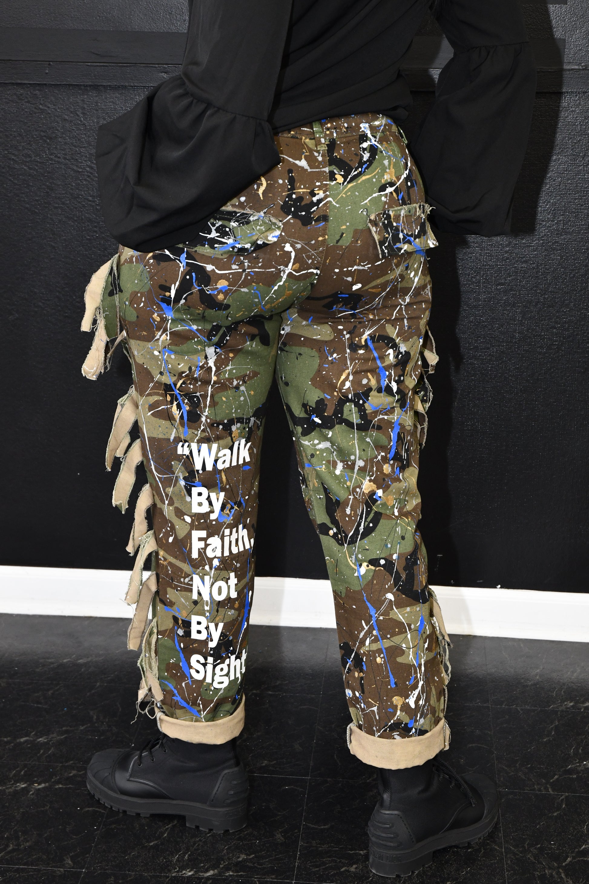 Camouflage pants with visible branding on a black background