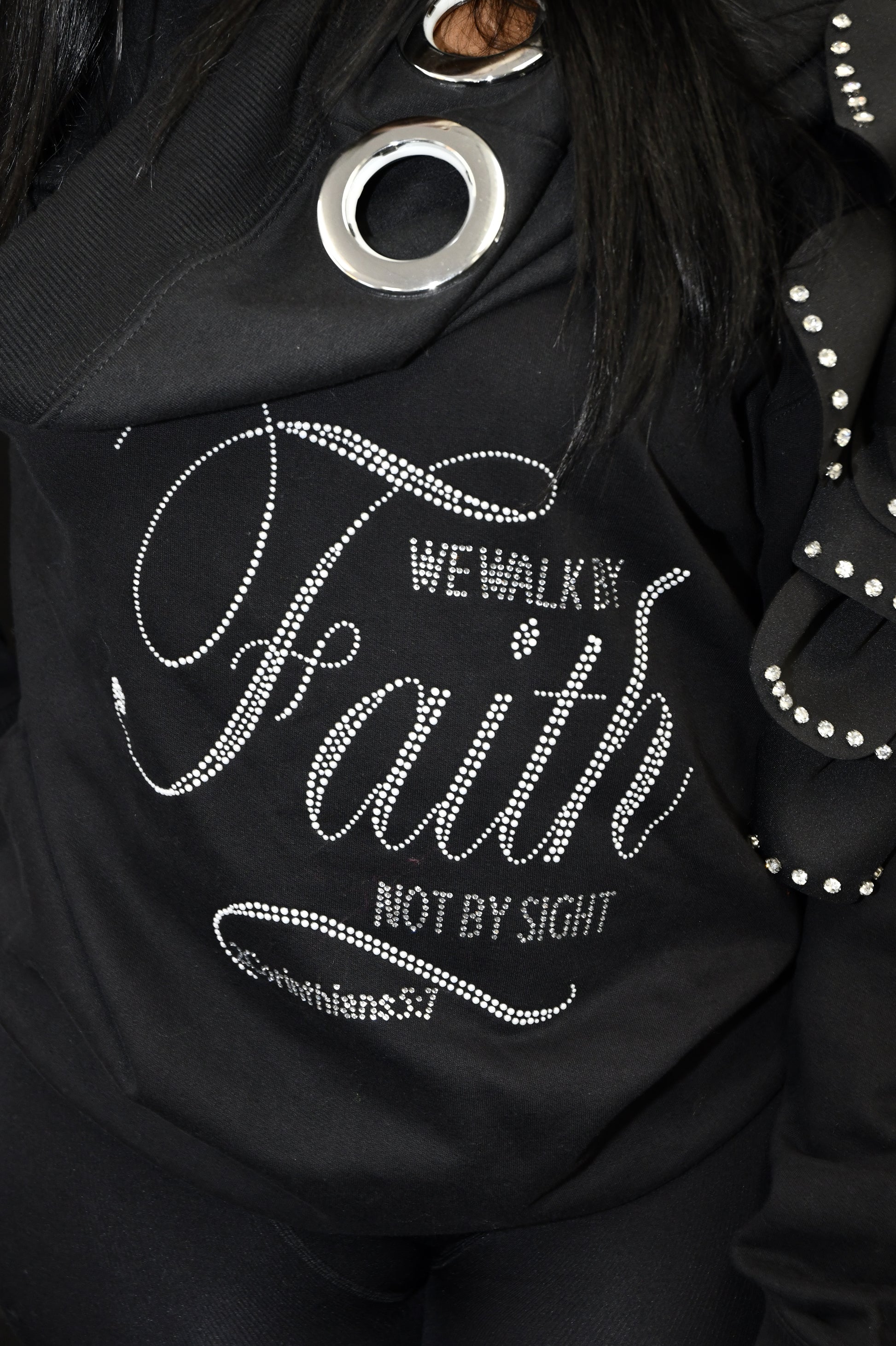 Black jacket with rhinestone-embellished text and designs on a dark background